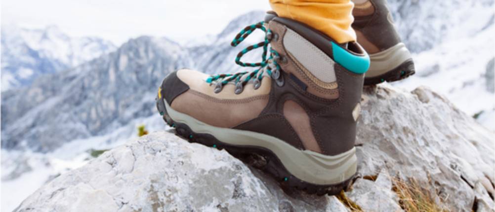 Bergschuhe Unisex Test: Eine Person mit Bergschuhen steht auf einem Felsen. 