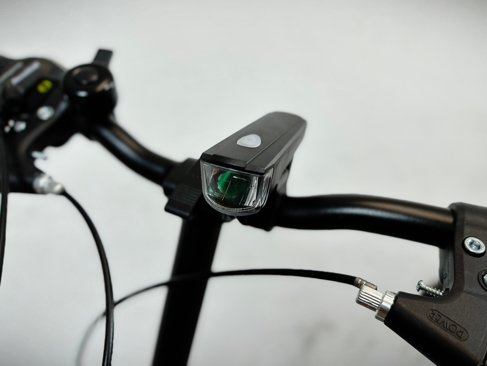 Nahaufnahme des batteriebetriebenen Frontlichts am Lenker des Bergsteiger Windsor. Der Lichtkopf zeigt nach vorn, der Taster liegt oben.