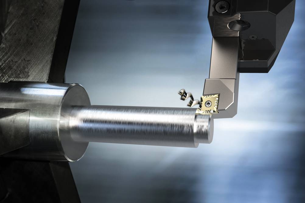 Bernardo-Drehmaschine im Test: ein Arm erzeugt an einem Metallteil einen Span – fotorealistische Grafik.