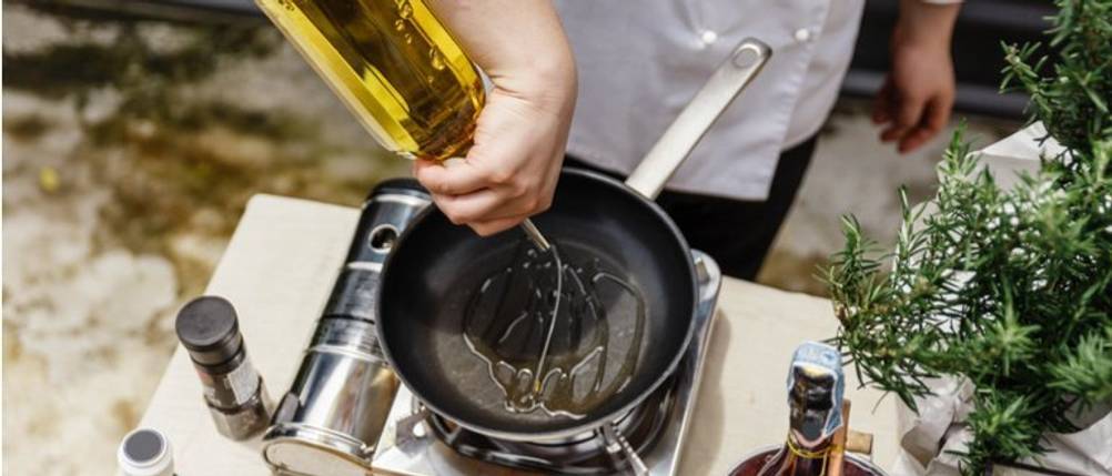 Bertolli-Olivenöl-Test: Ein Koch füllt Olivenöl in eine kleine Pfanne. 