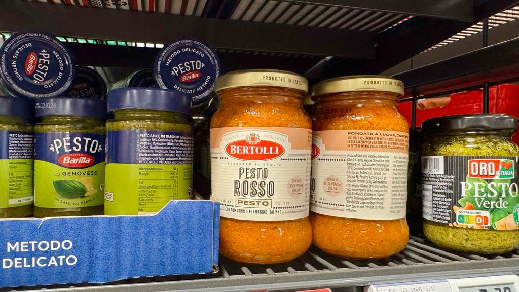 Pesto Rosso im Test: Mehrere Gläser stehen zwischen anderen Pesto-Sorten in einem Regal.