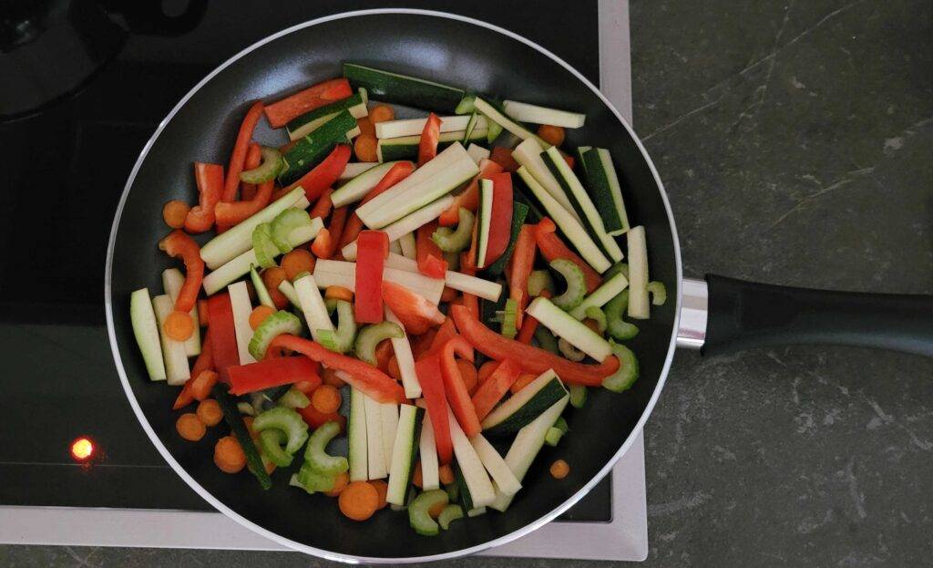 Beschichtete Pfannen im Test: beschichtete Pfanne mit frischen Gemüsestreifen