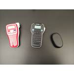 Drei Beschriftungsgeräte von Brother, Dymo und Supvan liegen nebeneinander auf einem schwarzen Tisch.