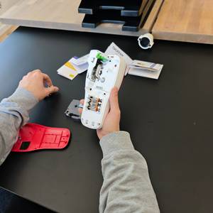 Batterien werden in einen roten Brother PTH100R eingesetzt.