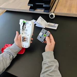 Ein Brother PTH100R mit der zugehörigen Rolle wird in der Hand gehalten.