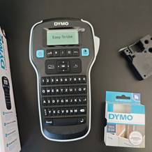 Ein schwarzes Dymo-Beschriftungsgerät liegt auf einem Tisch.