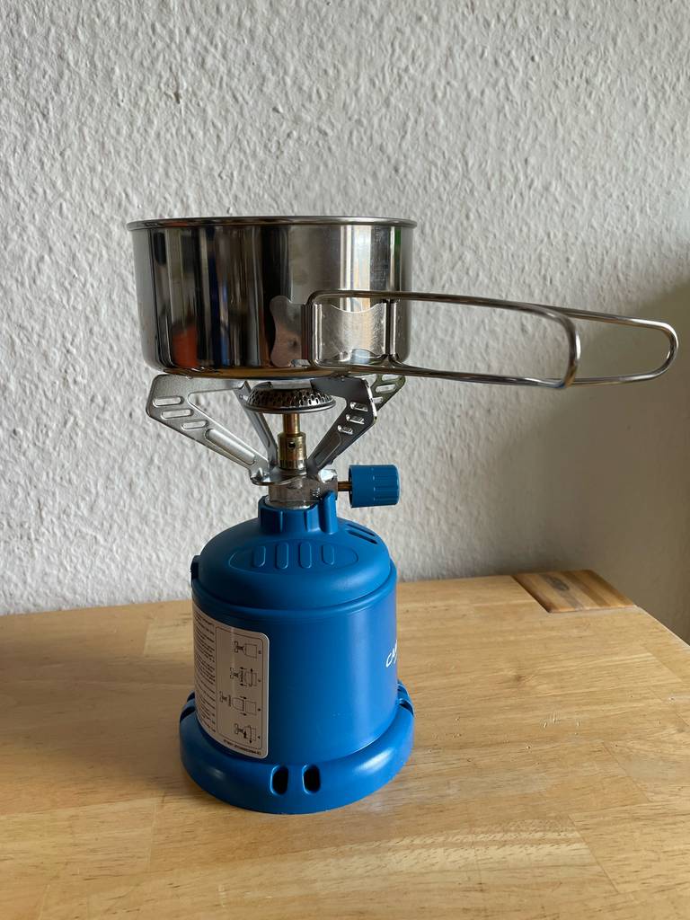 Der Topf eines getesteten Camping-Kochgeschirrs aus Edelstahl steht auf einer Kochflamme.