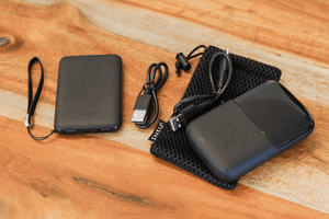 Leichte-Powerbank-Test: Zwei getestete Powerbanks liegen mit dem entsprechenden Zubehör auf einem Tisch.
