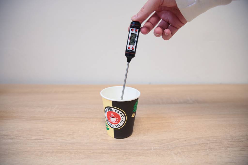 Coffee-To-Go-Becher-Pappe-Test: Die Temperatur des Kaffees wird mit einem Thermometer gemessen.