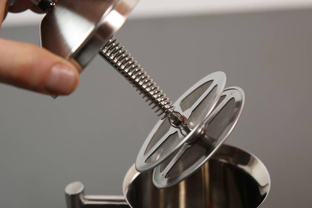 Test verschiedener Hand-Milchaufschäumer: Eine Person hält den Deckel mit dem Kolben eines Milchaufschäumers in der Hand.