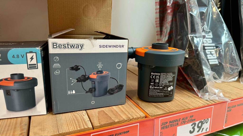 Im Test: eine elektrische SUP-Pumpe steht neben der Originalverpackung auf einem Verkaufsregal.