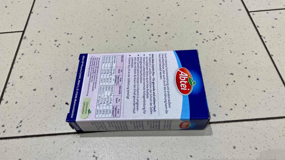 Rückseite einer Packung des Beta-Carotins im Test auf einer hellen Fließenoberfläche.
