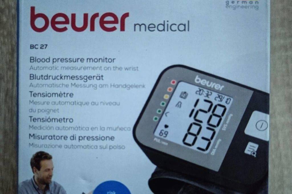 Getestetes Handgelenk-Blutdruckmessgerät: obere Ansicht der Originalverpackung eines Beurer Medical BC 27 Modells auf Holzuntergrund.