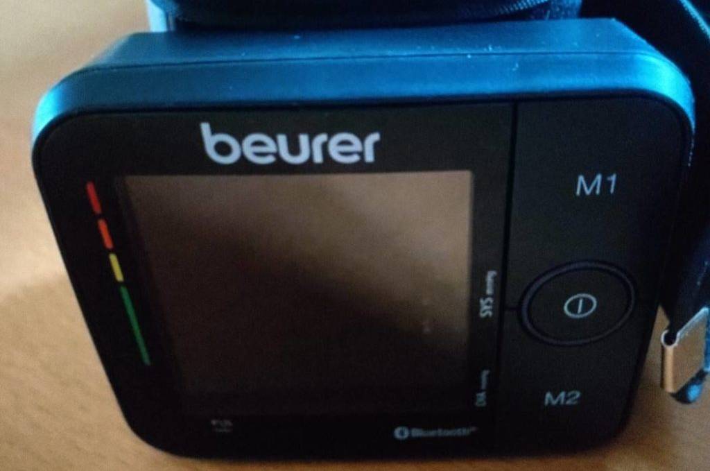 Handgelenk-Blutdruckmessgerät-Test: Nahaufnahme eines schwarzen Beurer BC 54 Modells vor hellem Holzhintergrund.