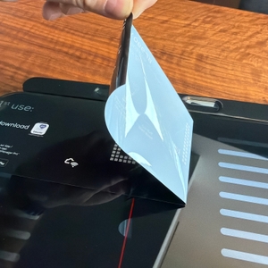 Eine Hand zieht eine Folie von der Beurer BF 990 ab