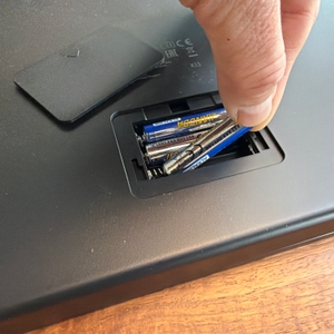 Eine Hand legt eine Batterie in die Beurer BF 990