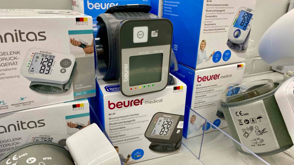 Beurer-Blutdruckmessgerät-Test: Ein Gerät auf einer Originalverpackung in einem Verkaufsregal zwischen anderen Produkten.