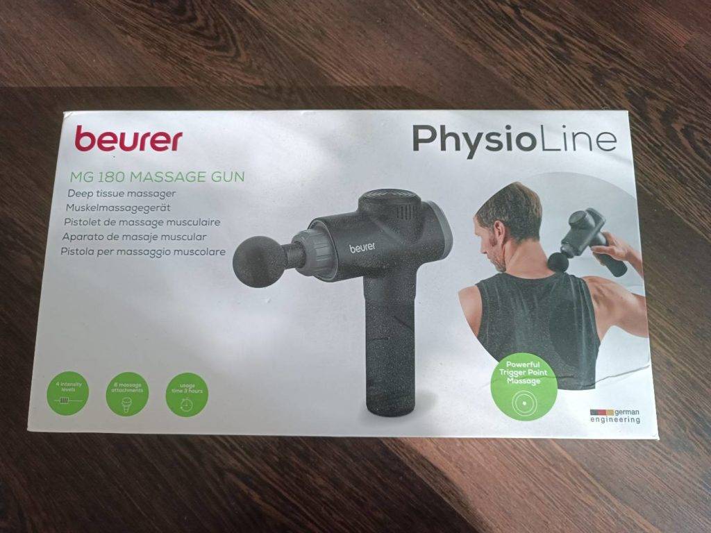 Originalverpackung einer Beurer Physio Line Massagepistole im Test auf Holzfläche.