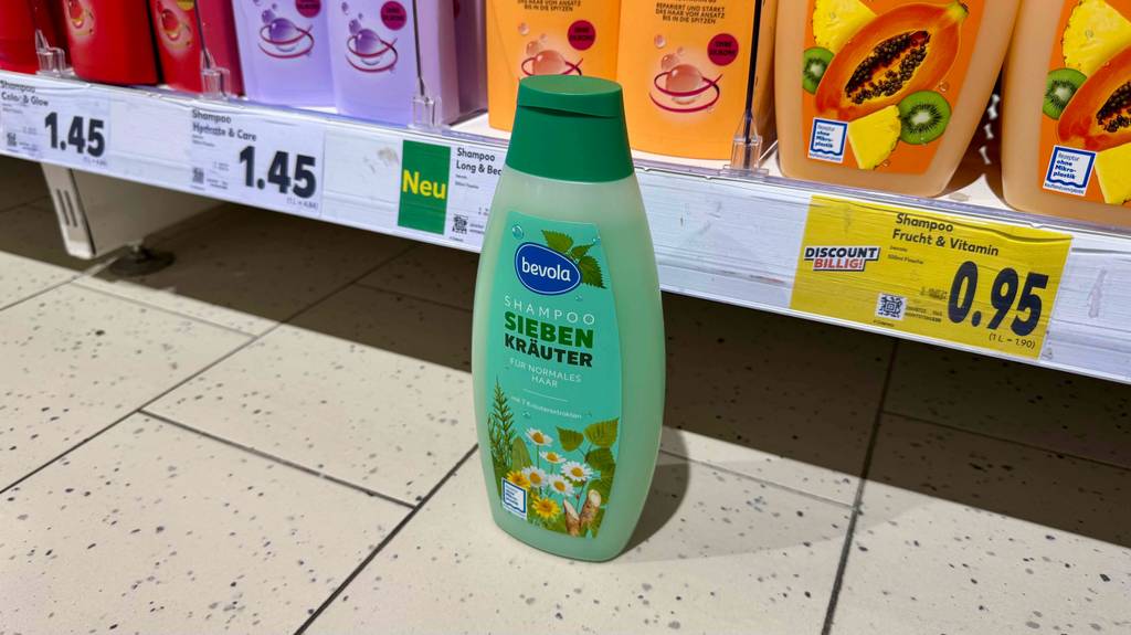 Kräuter-Shampoo-Test: Ein Shampoo mit sieben Kräutern steht vor einem Verkaufsregal mit weiteren Shampoos.