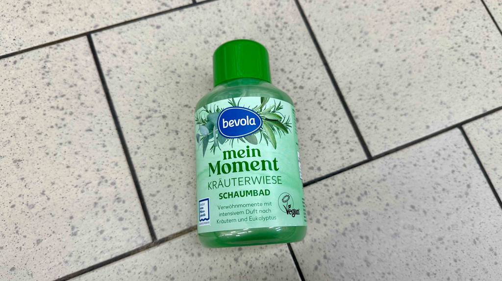 Getestet: Schaumbad in der Kunststoffflasche mit grüner Flüssigkeit liegt auf dem Boden.