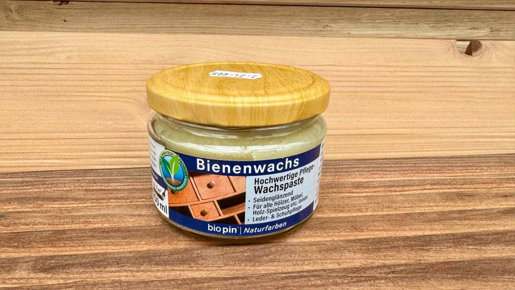 Auf einer Holzfläche steht das Bienenwachs im Test.