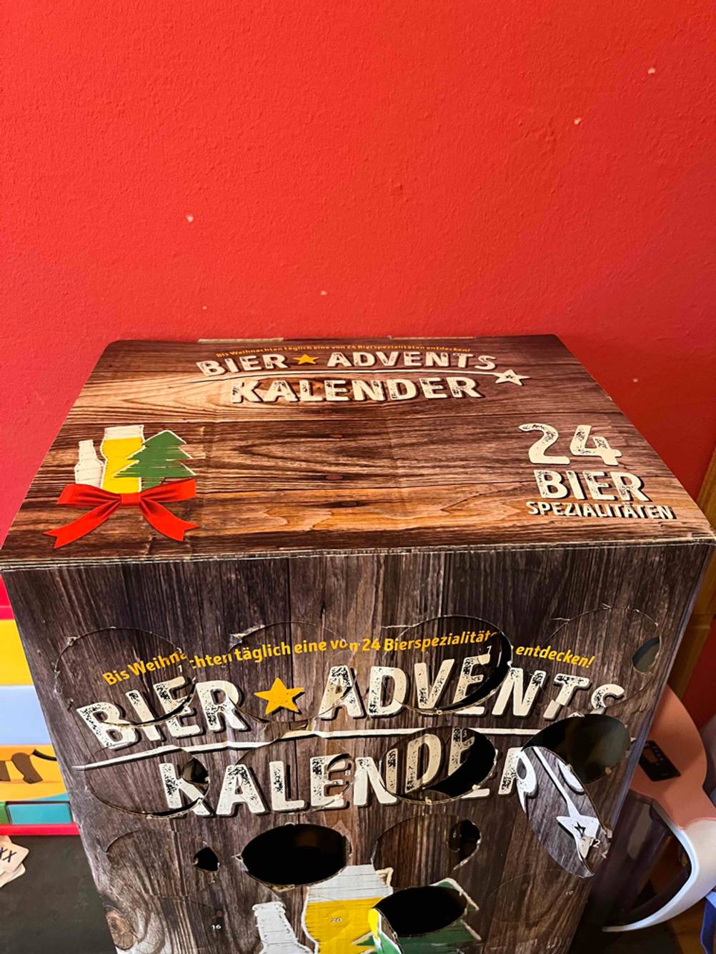 Bier-Adventskalender getestet: Oberseite eines Kalenders vor einer roten Wand.