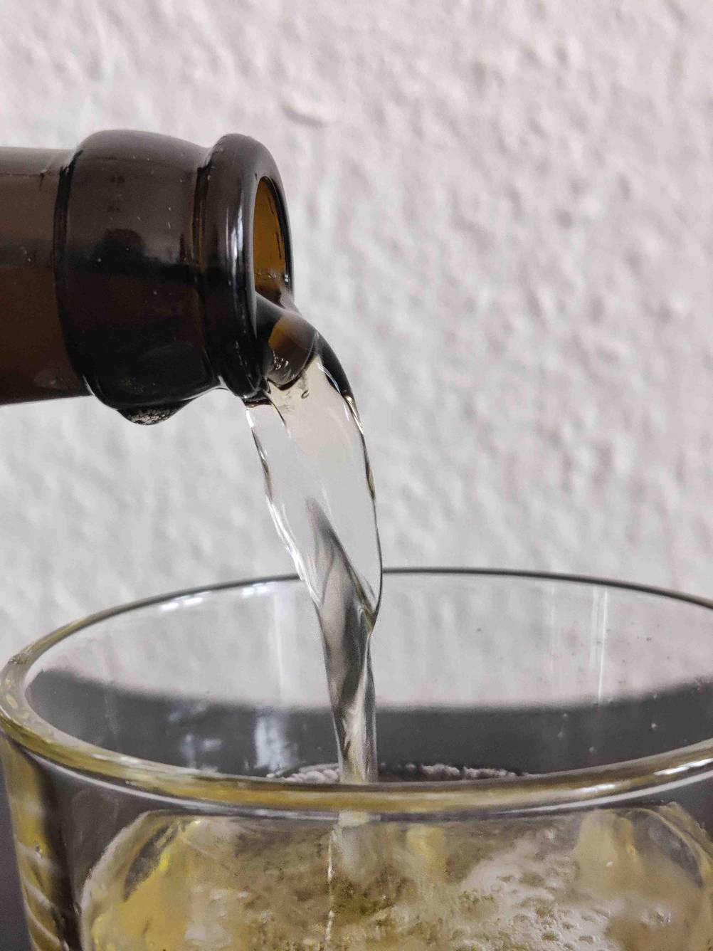 Nahaufnahme des Einschänkvorgangs eines Bieres im Test in ein Glas.