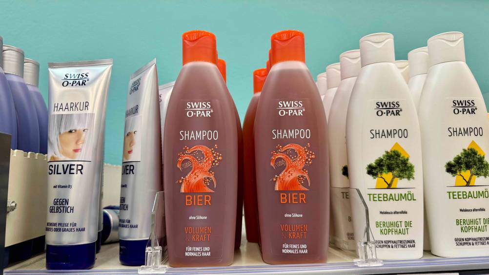 Bier-Shampoo im Test: Mehrere Flaschen auf eine Verkaufsregal neben anderen Produkten.