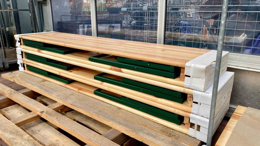 Mehrere getestete Bierzelttische übereinander gestapelt auf einer Holzpalette von schräg seitlich.