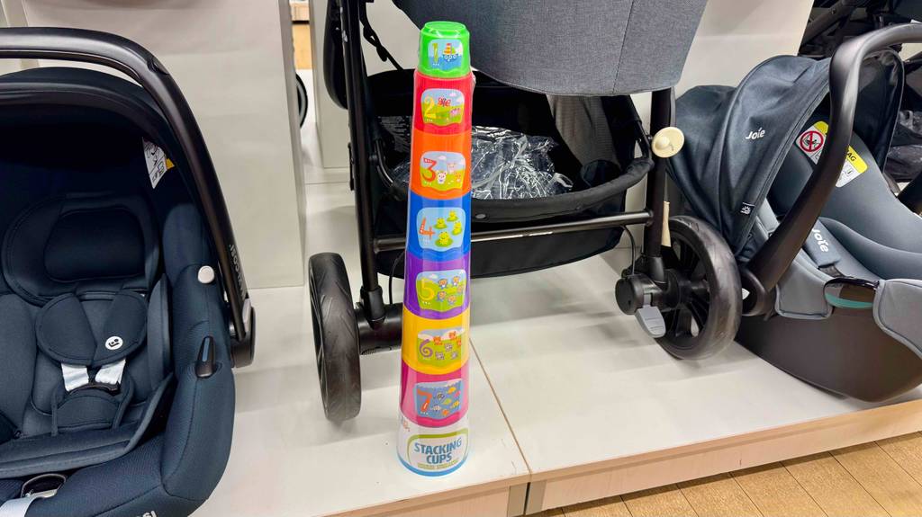 Getestet: Ein Stapelbecher inklusive Nummerierung und bunten Nummernbildern steht auf einem Ausstellungspodest mit Kinderwägen.