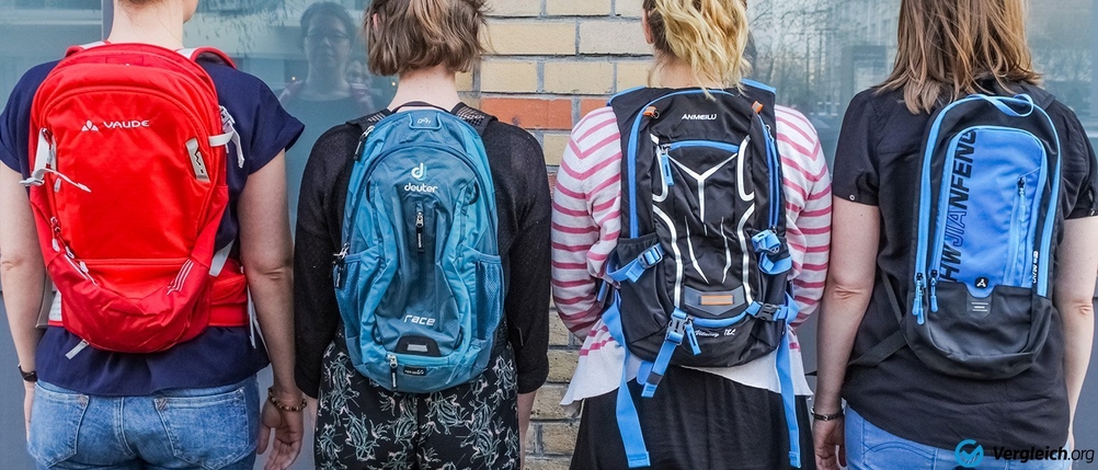 Rückenansicht von vier Personen mit verschiedenen Rucksäcken.