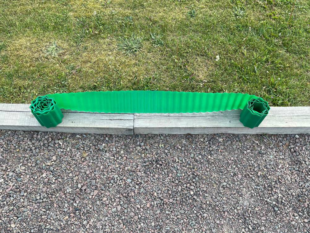 halb ausgerollte Rasenkante auf Holz