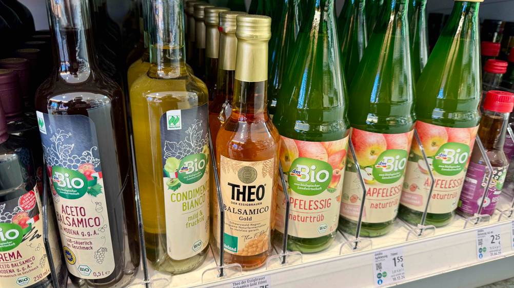 Mehrere Flaschen des Bio-Balsamico-Essig im Test in einem Verkaufsregal neben anderen Sorten.