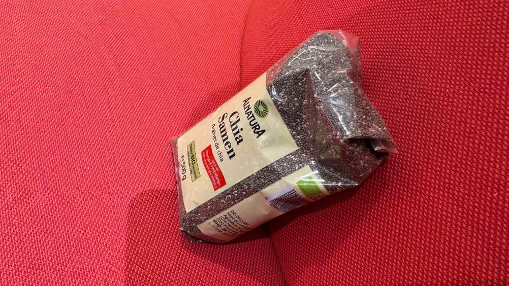 Eine Packung der getesteten Bio-Chia-Samen von schräg oben auf einem roten Polster.