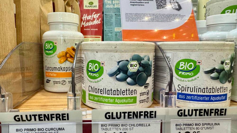 Mehrere Packungen stehen in einem Verkaufsregal neben anderen Produkten.