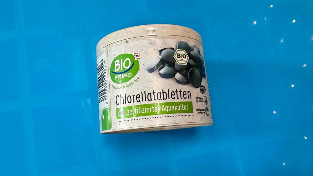 Auf einer blauen Fläche liegt eine Packung des getesteten Bio-Chlorellas.