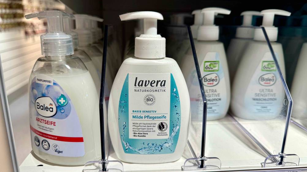 Mehrere Flaschen der Bio-Flüssigseife im Test in einem Verkaufsregal neben anderen Produkten.