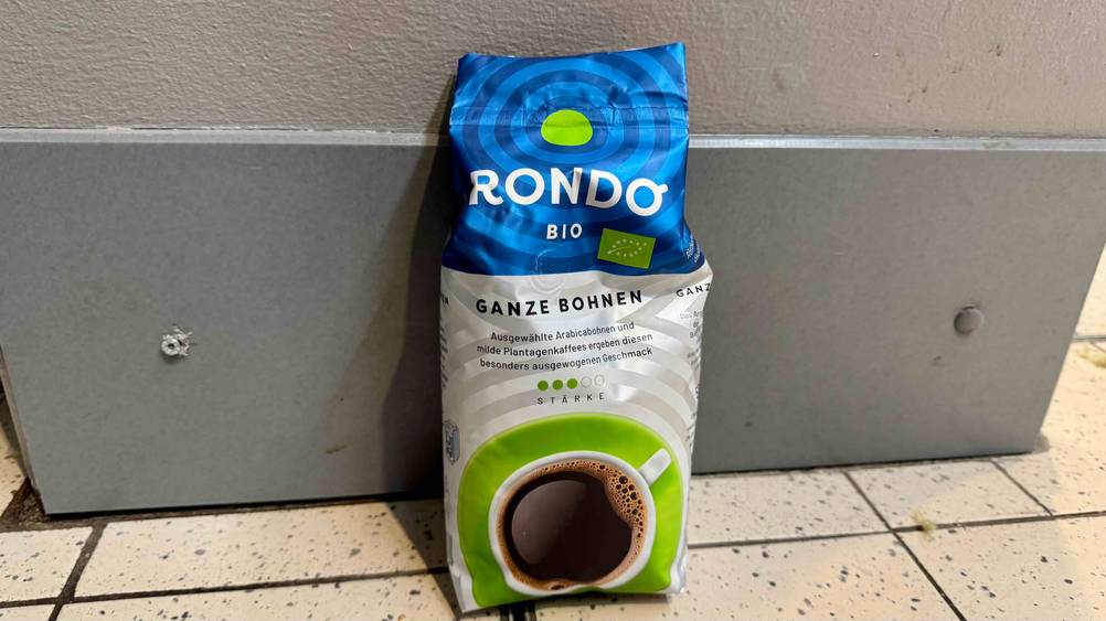 Eine Packung des Bio-Kaffee im Test lehnt an einer grauen Wand.