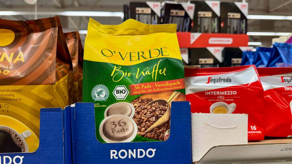 Bio-Kaffeepads-Test: Eine Packung steht in einem Verkaufsregal neben anderen Produkten.