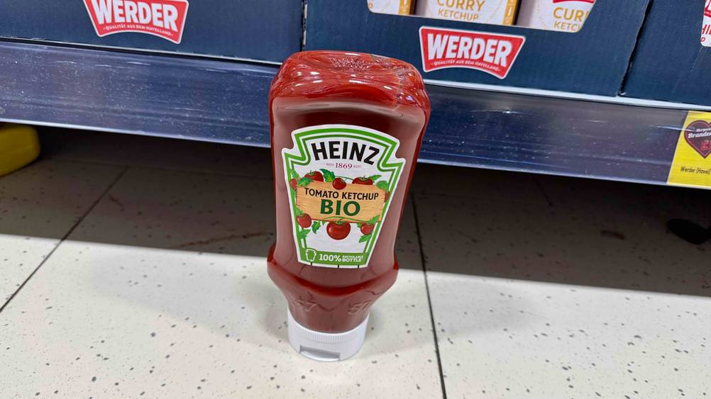 Bio-Ketchup im Test: Eine Flasche von schräg oben vor einem Verkaufsregal auf dem Boden.
