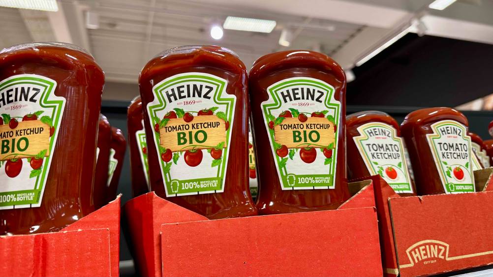 Mehrere Flaschen des getesteten Bio-Ketchups in Kartons auf einem Verkaufsregal.