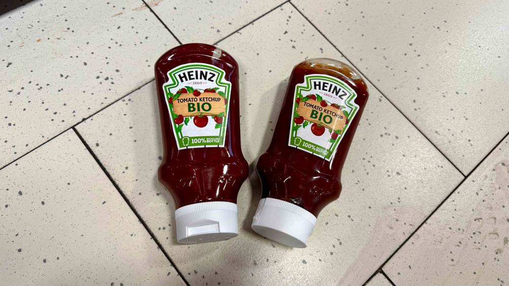 Bio-Ketchup-Test: Zwei Flaschen nebeneinander auf einem hellen Fließenboden.