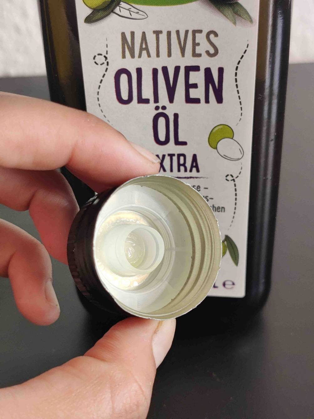 Bio-Olivenöl getestet: Eine Hand hält den Deckel vor das Label.