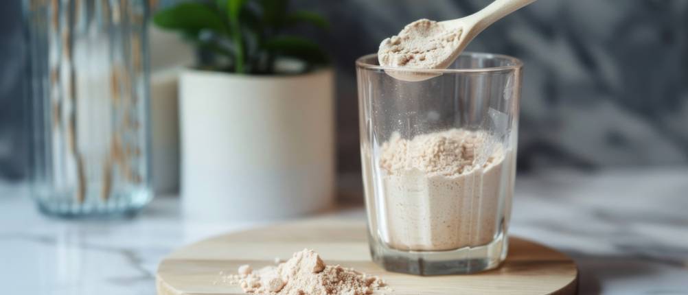 Bio-Proteinpulver-Test: Aus einem Glas wird mit einem Löffel Proteinpulver entnommen. 