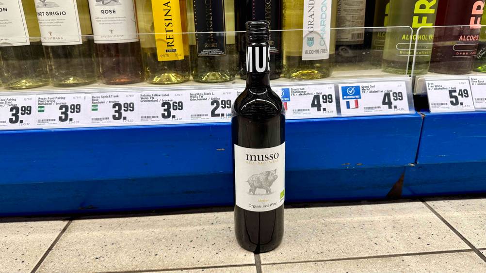 Bio-Rotwein im Test: Eine Flasche steht vor einem Verkaufsregal mit Preisangaben.
