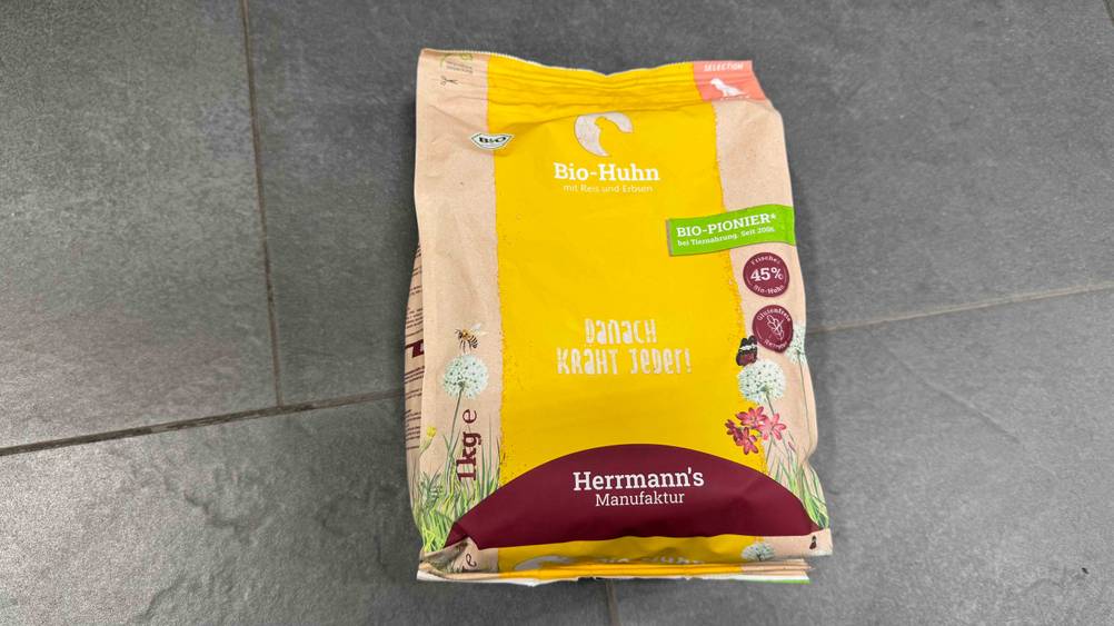 Auf einem grauen Fließenboden liegt das getestete Bio-Trockenfutter Hund.