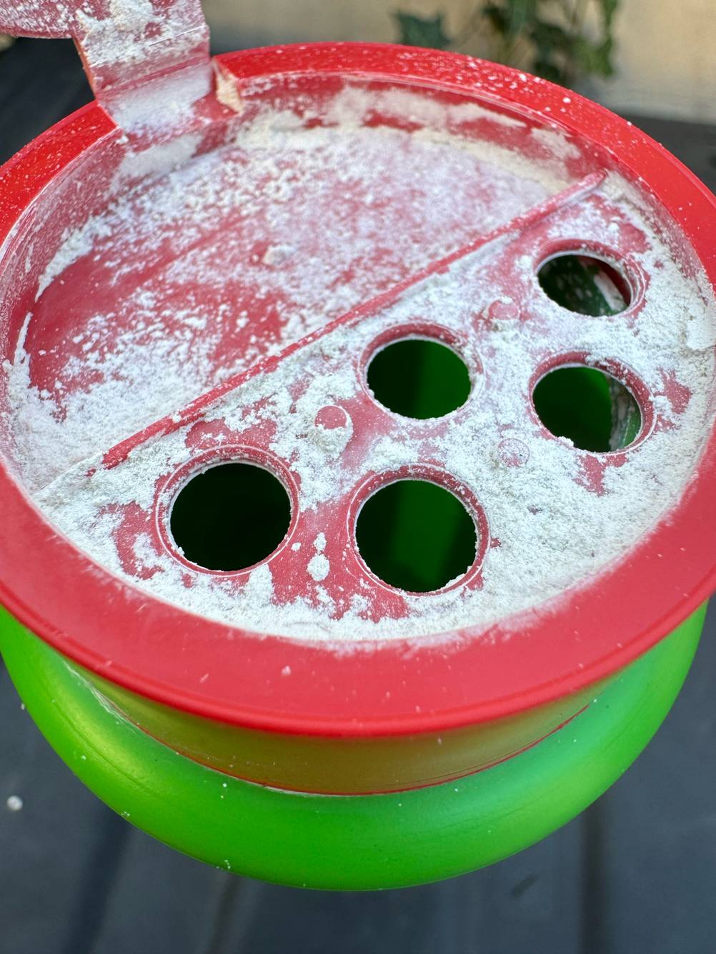 Biotonnenpulver getestet: Blick von oben auf eine geöffnete Flasche mit Löchern und Pulverrückständen.