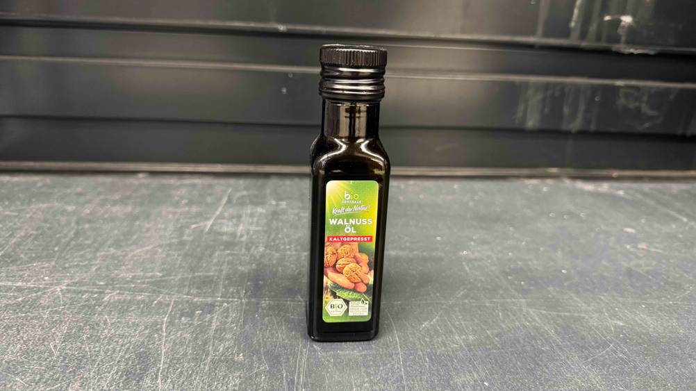 Bio-Walnussöl im Test: Eine Flasche auf einer grauen Fläche stehend.