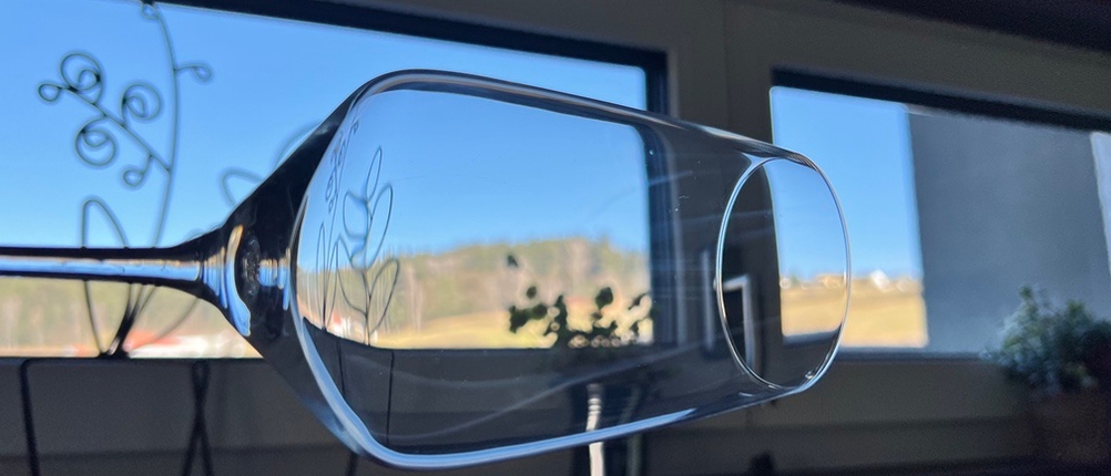 Ein Weinglas wird gegen das Licht gehalten