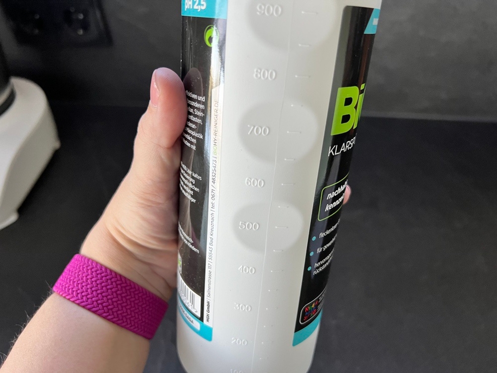 Eine Hand hält den Biohy-Klarspüler so, dass man die Mengenangabe auf der Seite lesen kann